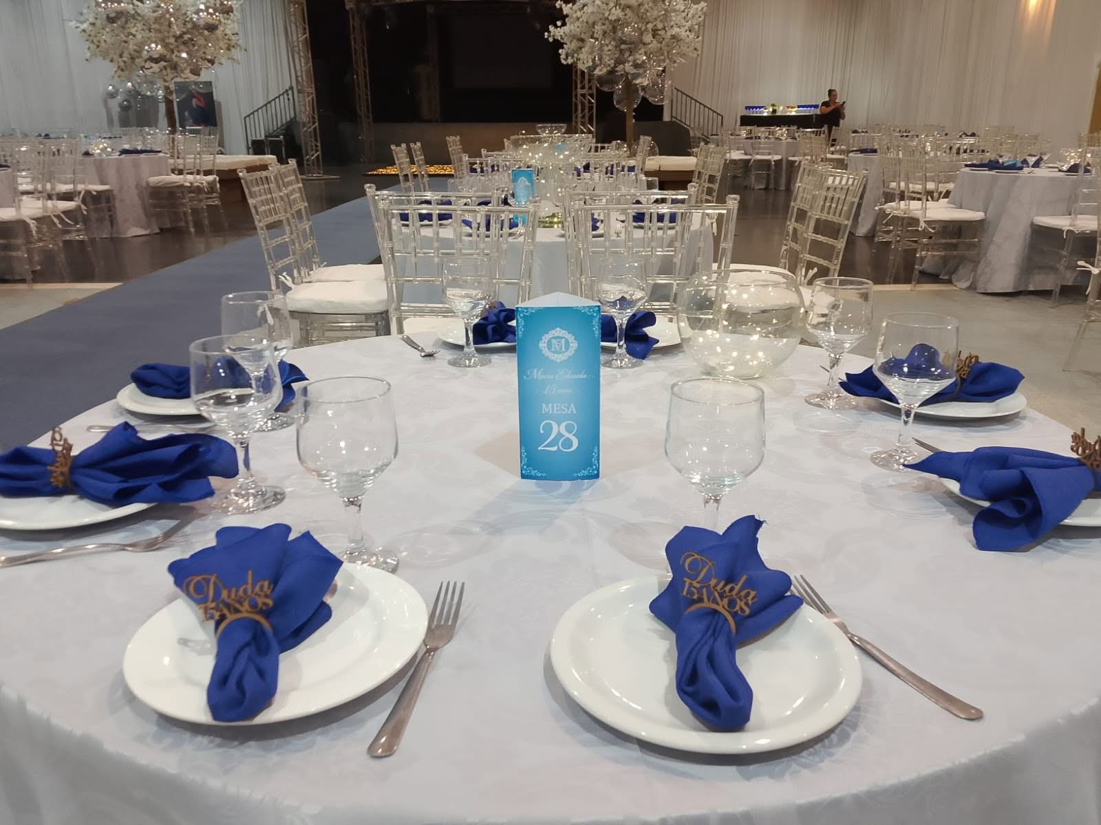 Mesa posta com toalha branca e guardanapos azul-rei para festa de 15 anos